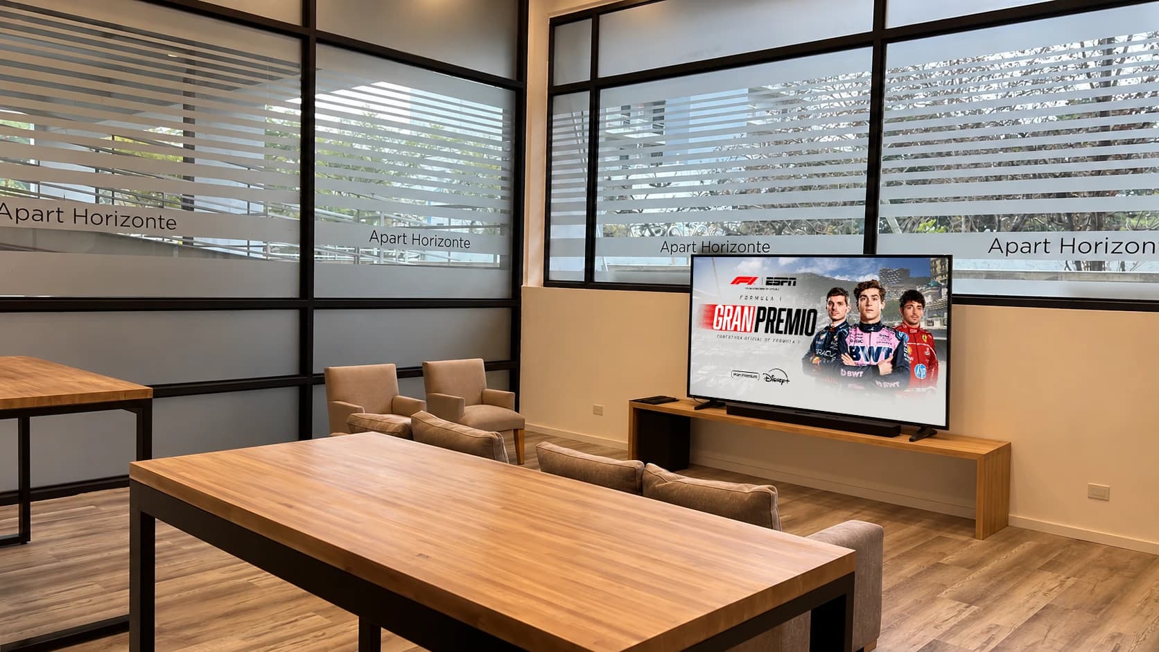 Lobby de Apart Horizonte con la TV de gran formato pasando Fórmula 1